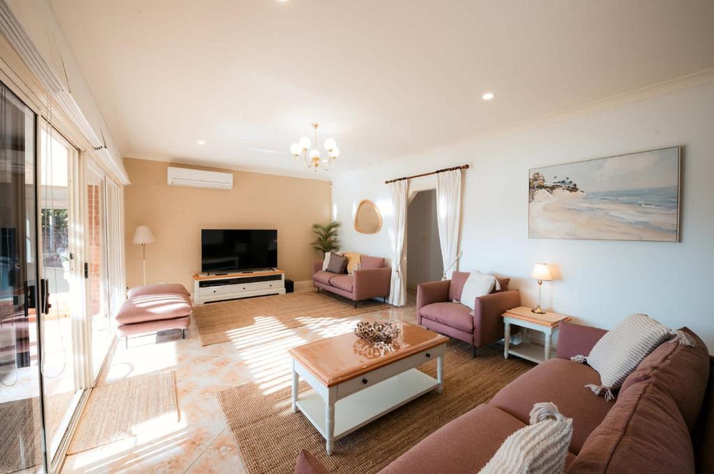 a living room with a couch and a table at Spacious Lake Front Home- Private Beach in Encounter Bay