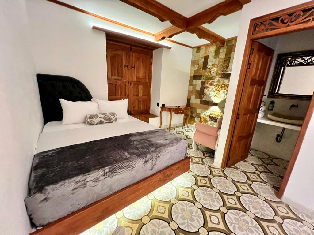 a bedroom with a large bed and a bathroom at Hotel Boutique Sagrado Corazon in Abejorral