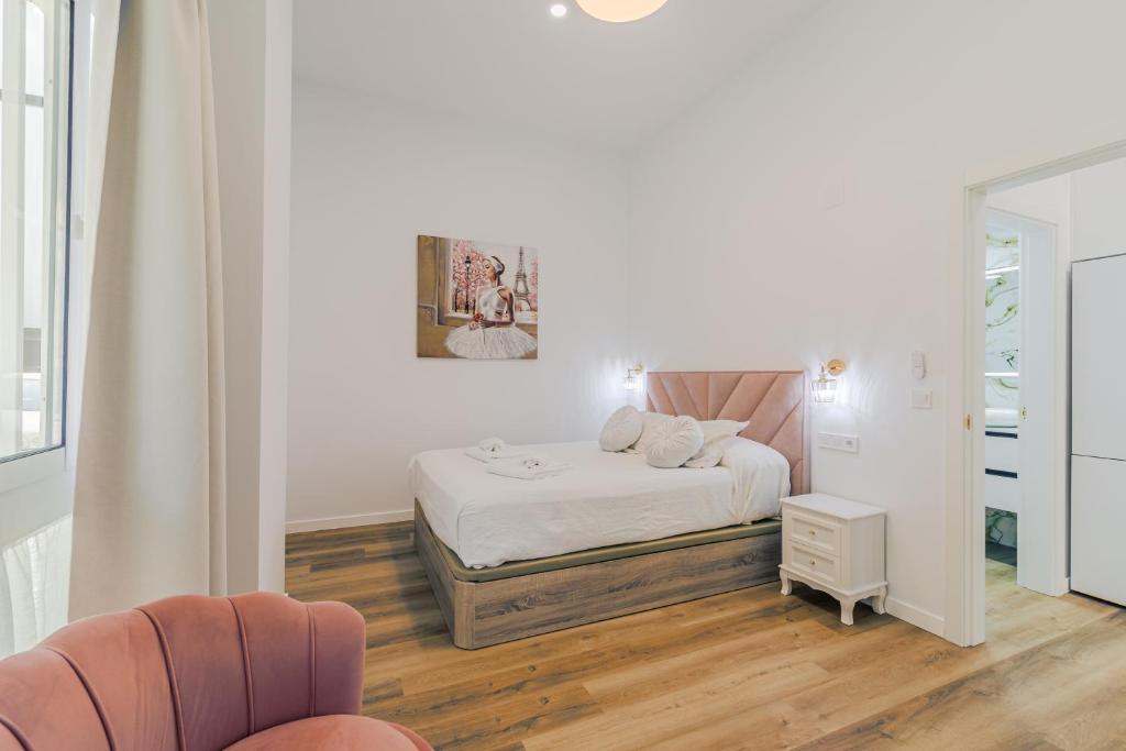 a white bedroom with a bed and a mirror at Luxury Apartment Mª Luisa Park & Plaza de España in Seville