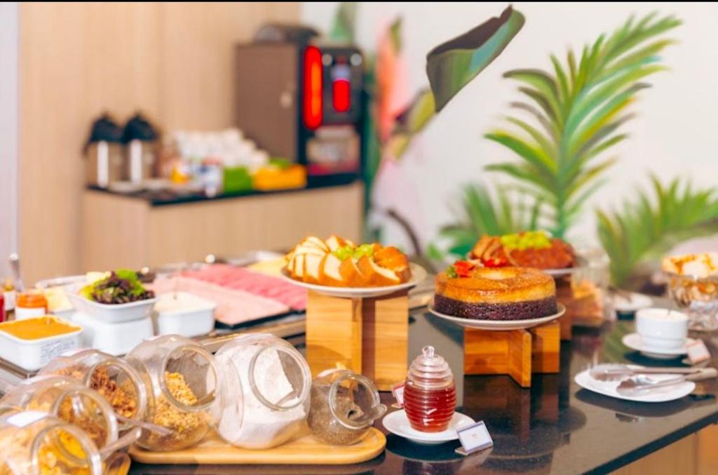 a table topped with different types of food on plates at Blend Marista! Café da manhã Premium no Ibis! in Goiânia