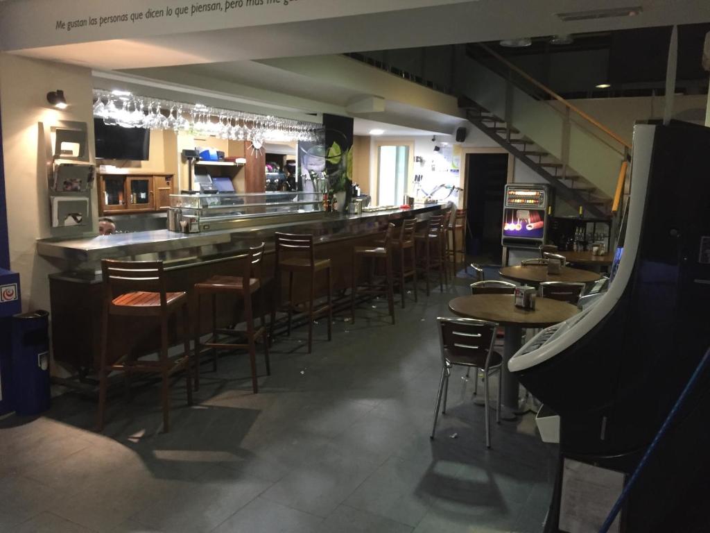 eine Bar in einem Restaurant mit Tischen und Stühlen in der Unterkunft Pension Oasis in Zamora