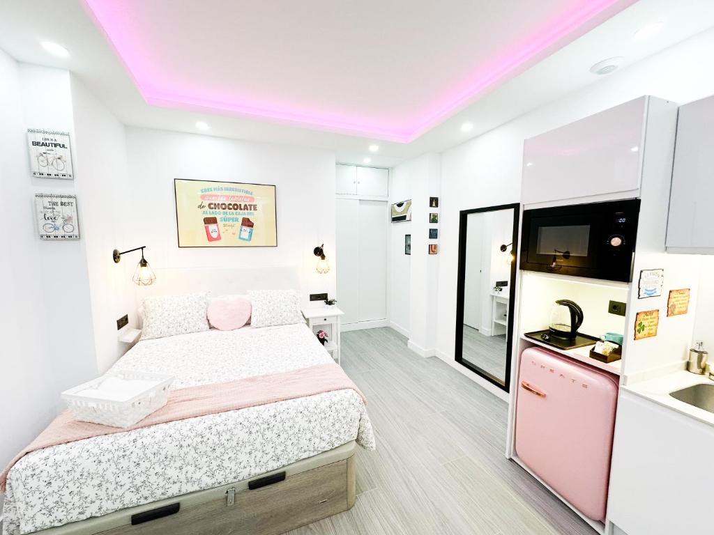 Habitación blanca con cama y lavabo en La Placita Boutique Trinidad, en Málaga