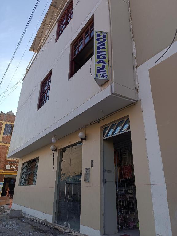 伊察Hospedaje El Cairo的一栋白色建筑，侧面有一块招牌