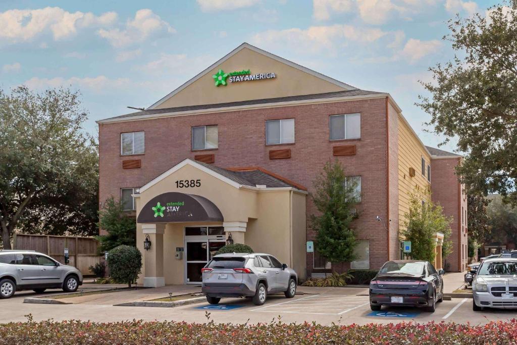 Un hotel con coches aparcados en un estacionamiento. en Extended Stay America Suites - Houston - Katy Freeway - Energy Corridor, en Houston