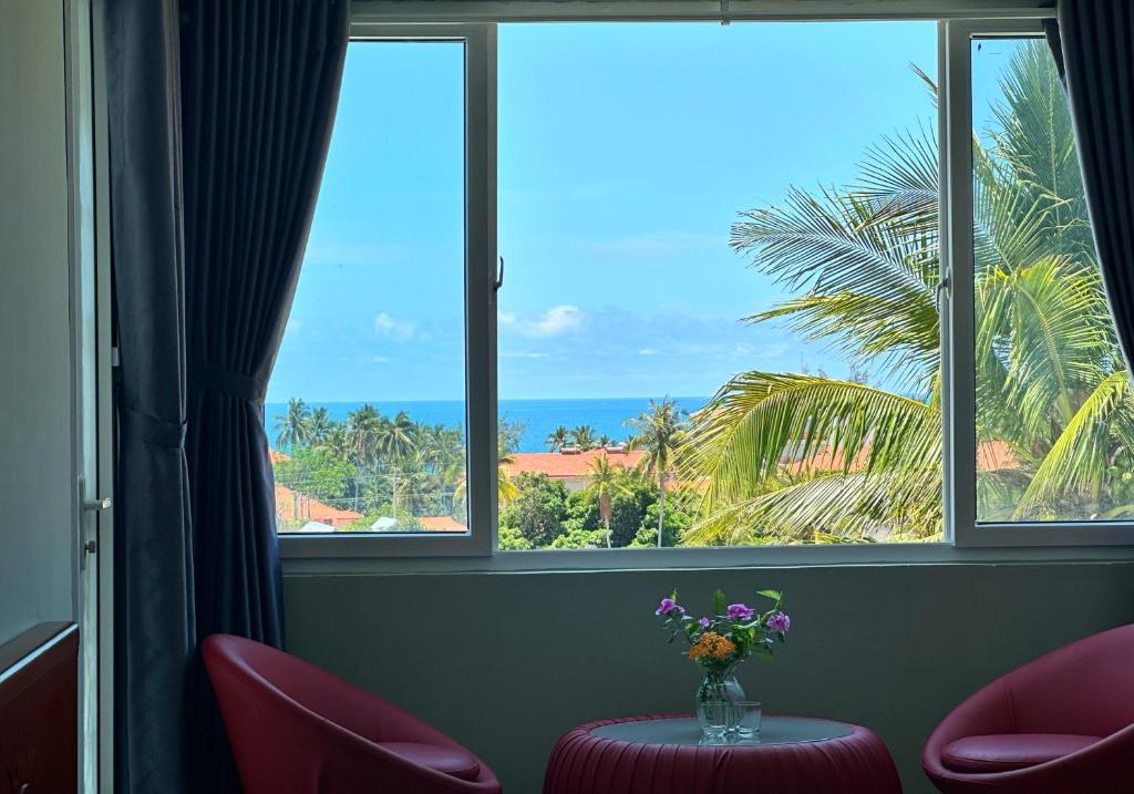 a room with a table with a vase of flowers at SnS Muine Homestay in Mui Ne