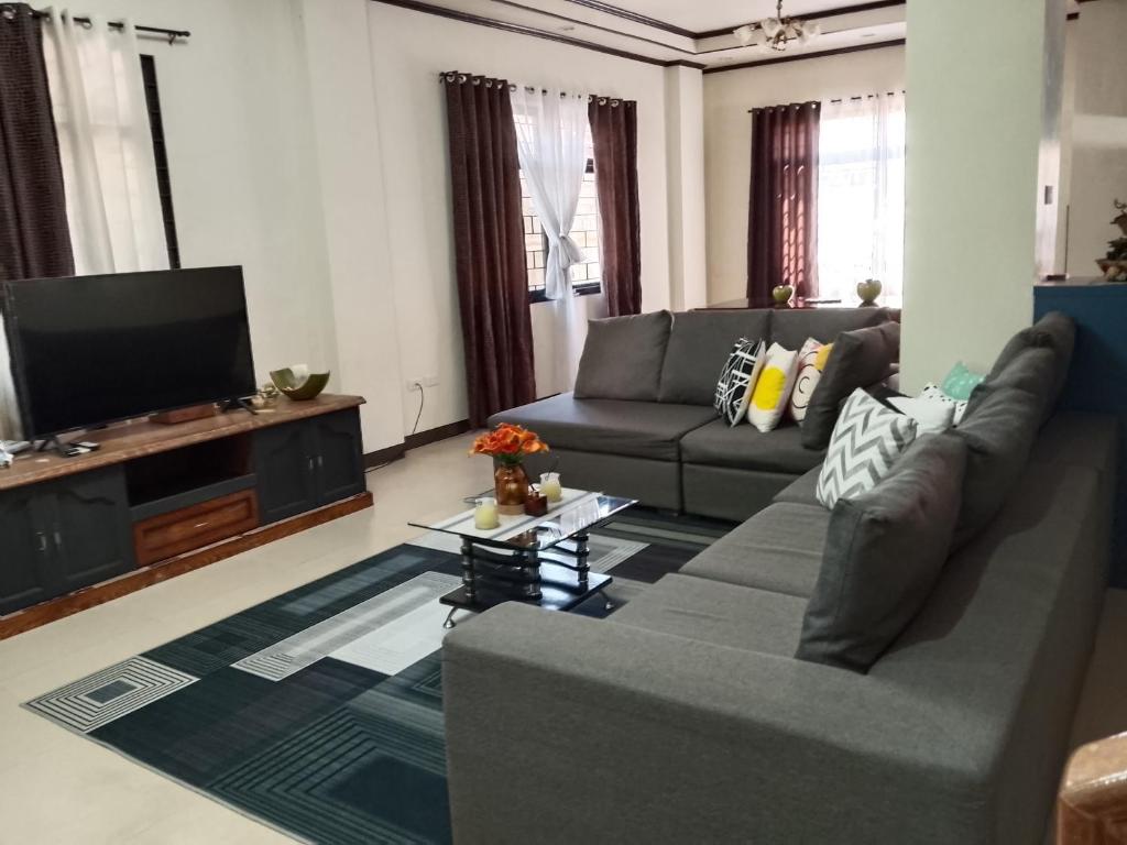 Una sala de estar con un sofá y un televisor de pantalla plana. en Balay 257 Camp 7, Baguio City, en Baguio
