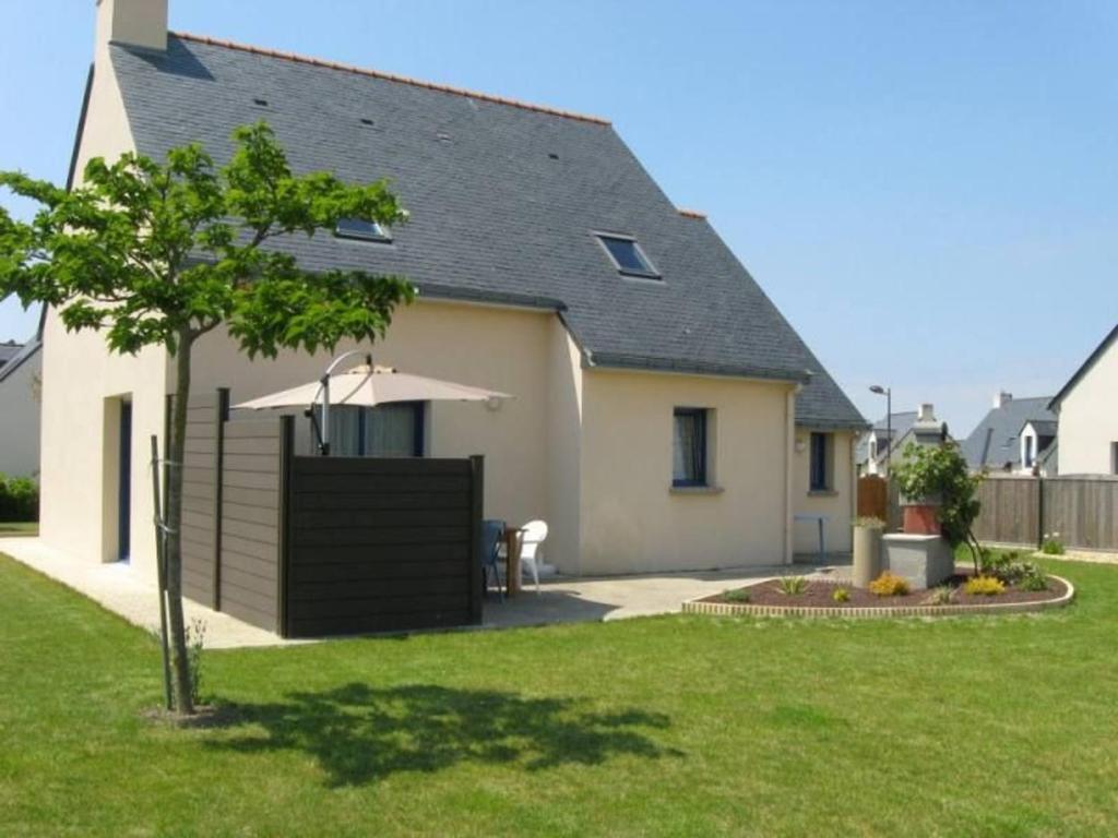 a house with an umbrella and a grass yard at Gîte calme proche plage et commerces au Croisic avec jardin, Wi-Fi, 4 chambres - FR-1-306-1308 in Le Croisic