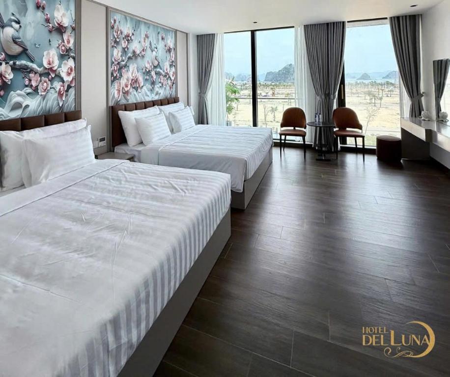 a hotel room with two beds and a large window at Hotel Del Luna in Kon Rung (1)