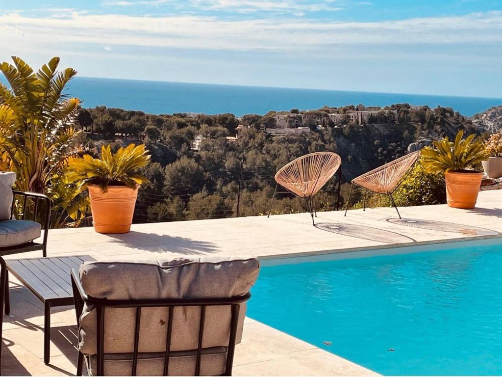 une piscine avec des chaises et une vue sur l'océan dans l'établissement Villa à Cassis avec piscine et climatisation - FR-1-770-47, à Cassis