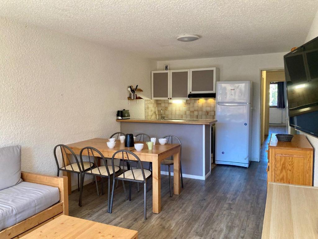 une cuisine et une salle à manger avec une table et un réfrigérateur dans l'établissement Appartement fonctionnel 2 pièces, animaux admis, au pied des pistes - FR-1-811-41, à Les Deux Alpes
