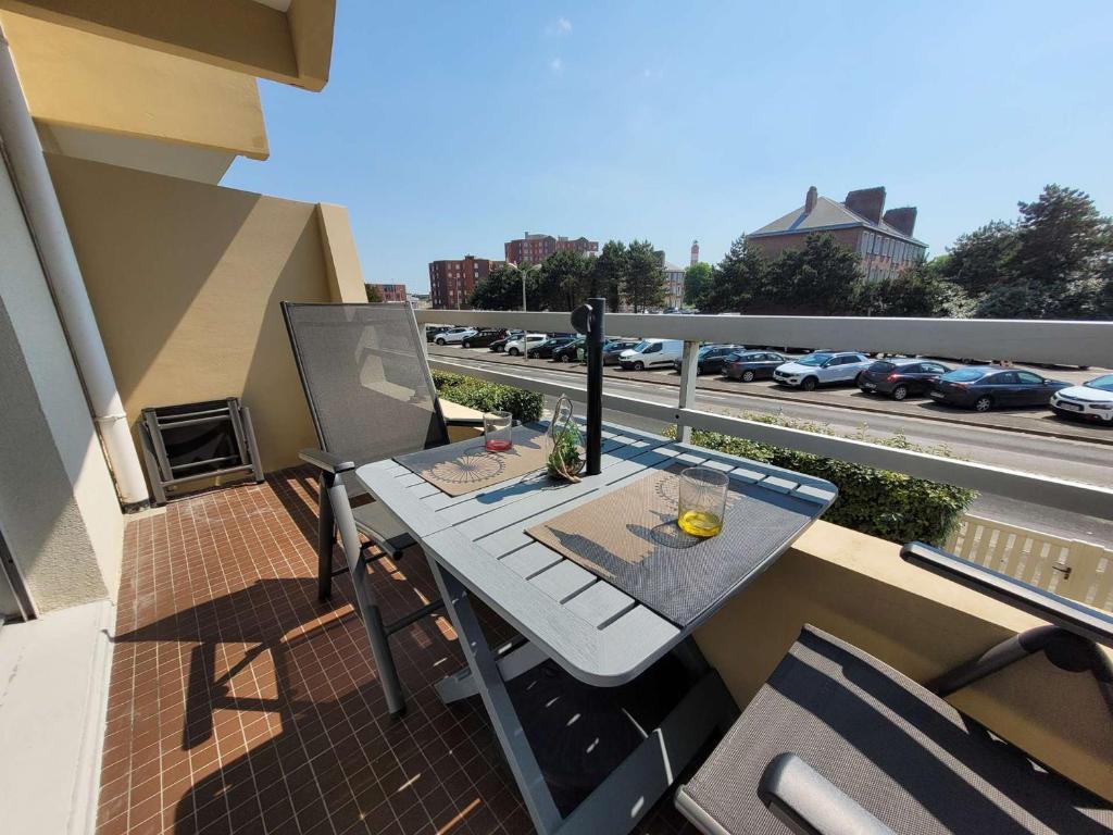 - une table sur un balcon avec vue sur la rue dans l'établissement Studio lumineux avec balcon sud et parking à Berck-Plage - FR-1-674-51, à Berck-sur-Mer