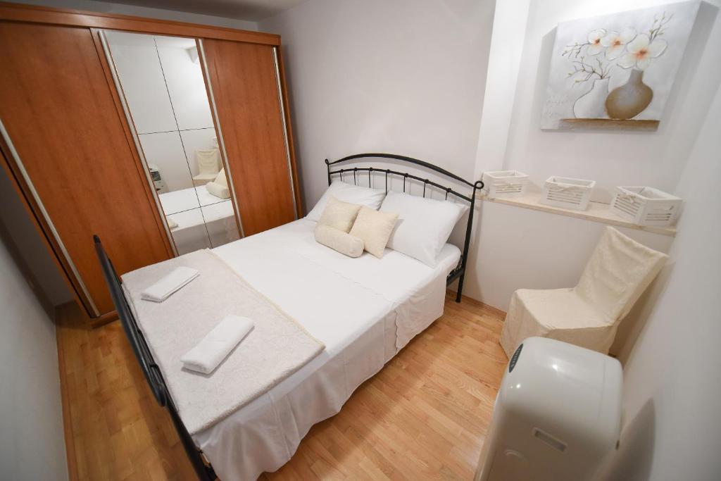 een kleine slaapkamer met een bed en een stoel bij Apartment Duje in Split
