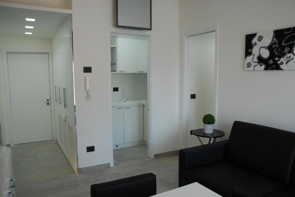 un soggiorno con pareti bianche e un divano nero di LHP Suite Rapallo a Rapallo