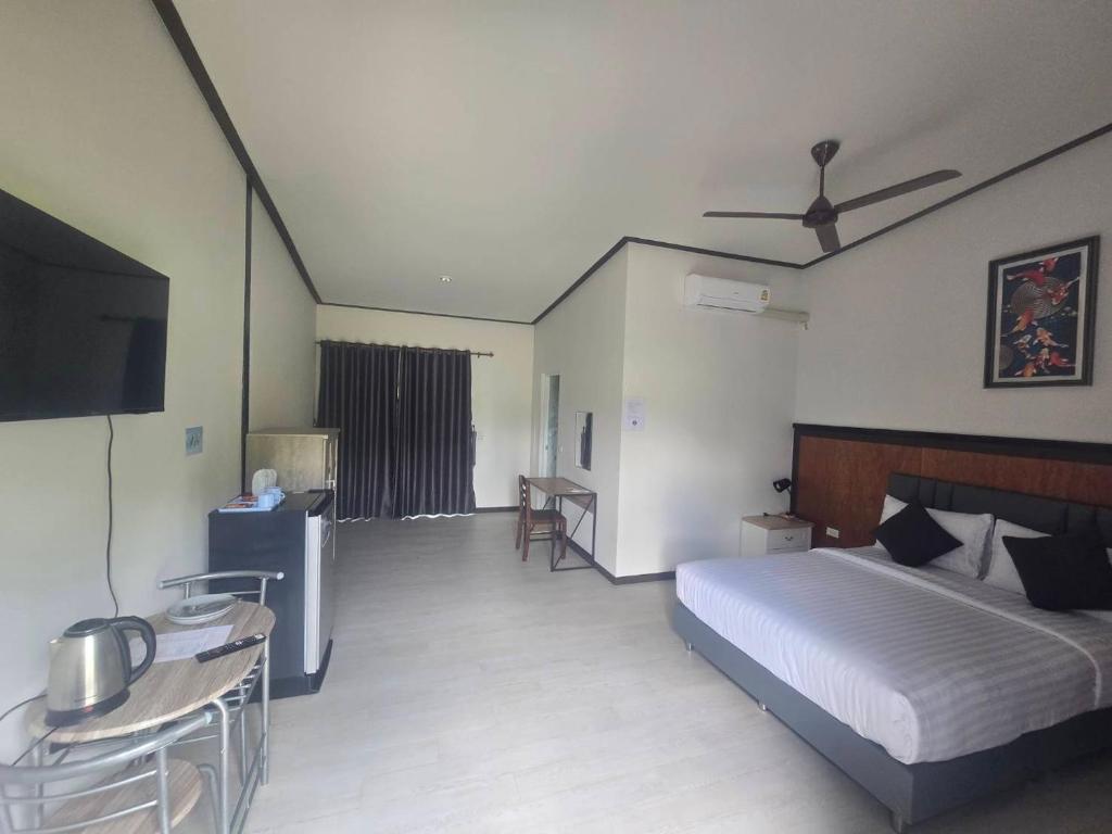 une chambre avec un lit, une table et une télévision dans l'établissement Riverhill khaoyai บ้านกล่อง, à Ban Bung Toei