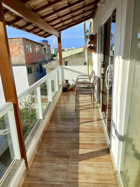 a balcony of a house with two chairs on it at Casa Refúgio da Prainha in Arraial do Cabo