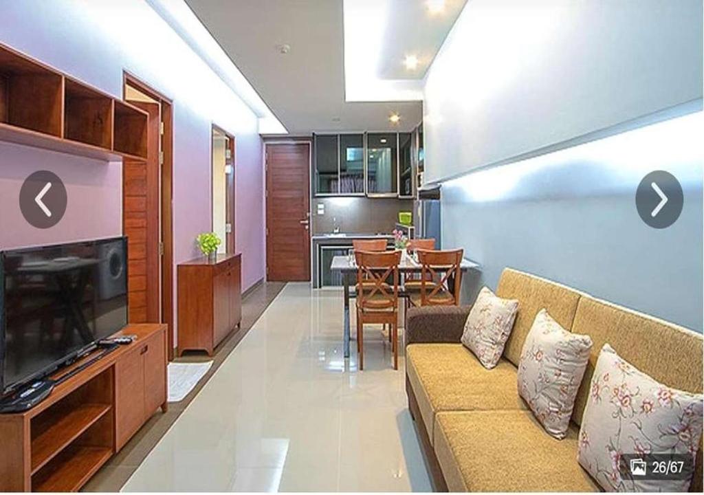 a living room with a couch and a dining room at Lasalle Park Serviced Apartment at Lasalle 75 in Bangna