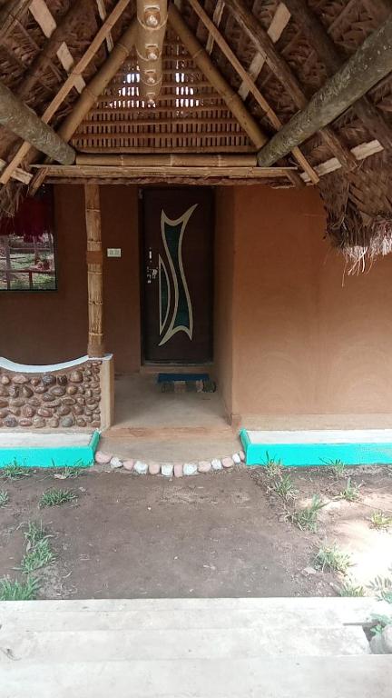 a building with a door with a painting on it at Vihara Mud House in Marayoor