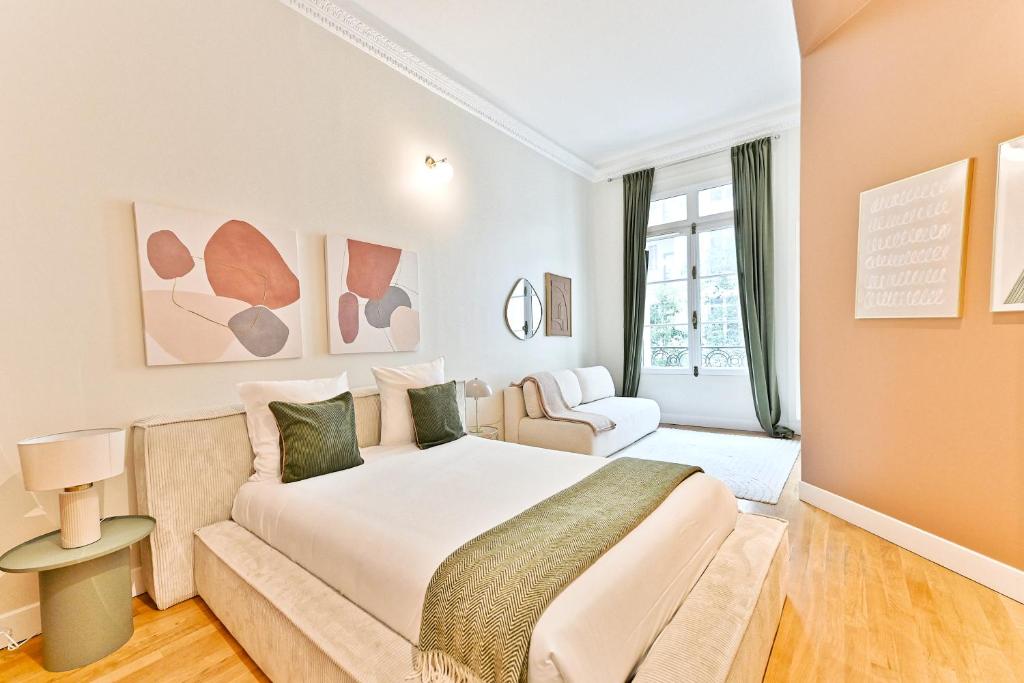 une chambre avec un grand lit et un canapé dans l'établissement Appartement moderne et climatisé - Arc de Triomphe, à Paris
