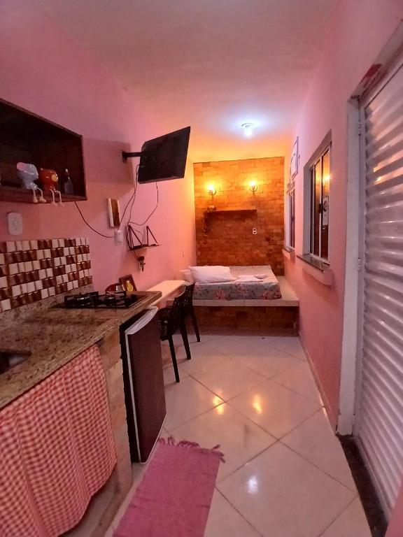 a room with a kitchen and a room with a bed at Mini casa pé na areia in Ilhéus