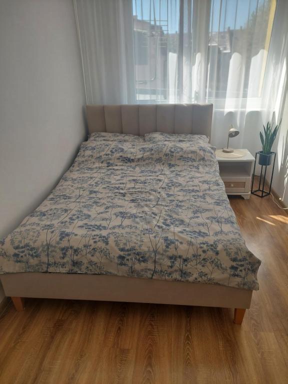 a bedroom with a bed with a blue comforter at Apartament Centrum przy Placu Zwycięstwa in Gryfice