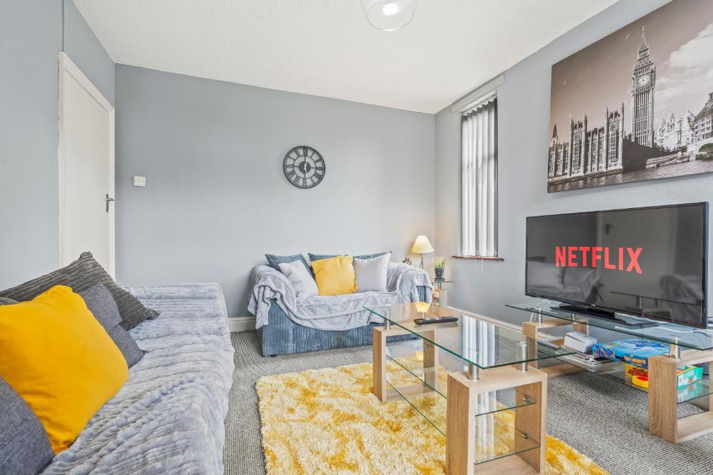 a living room with a couch and a tv at Spacious 4-Bedroom Home in Peaceful Coventry Spot in Parkside