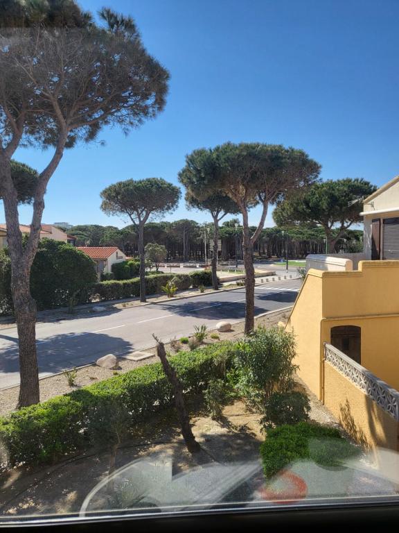 - une vue depuis la fenêtre d'une rue arborée dans l'établissement Le Barcares 100 m plage et commerces, à La Celle-sous-Gouzon