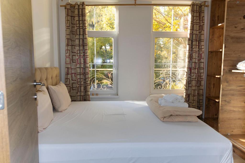 ein Schlafzimmer mit einem großen weißen Bett mit einem Fenster in der Unterkunft Center Apartments The Quiet Luxury 1 in Plowdiw