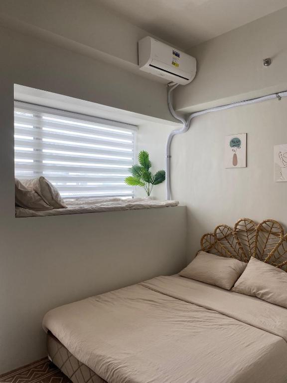 een kleine slaapkamer met een bed en een raam bij Casa Moderna Iloilo in Iloilo City