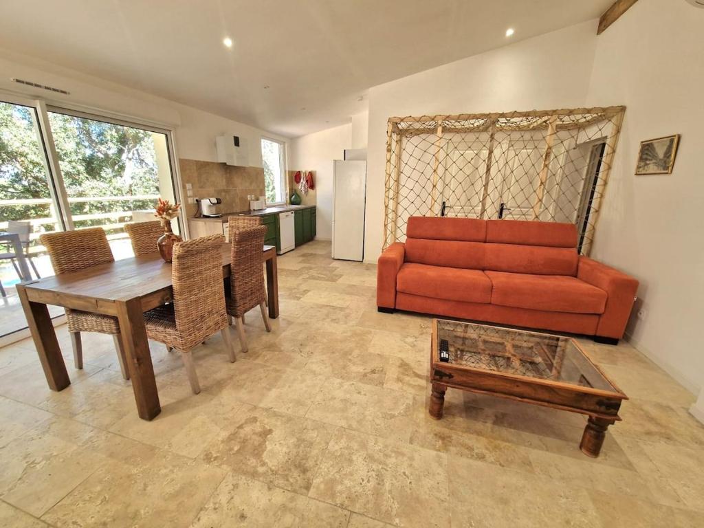 un salon avec un canapé rouge et une table dans l'établissement Opetitparadis, à Six-Fours-les-Plages