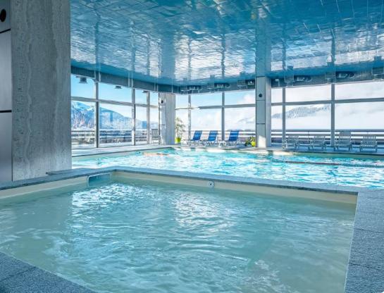 une piscine avec de l'eau bleue dans un immeuble dans l'établissement Mont arbois megeve, à Megève