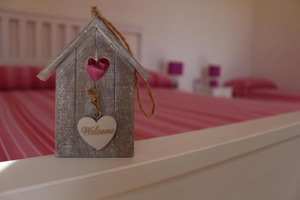 a small house with a heart on a bed at Marelaguna Rooms in Cavallino-Treporti