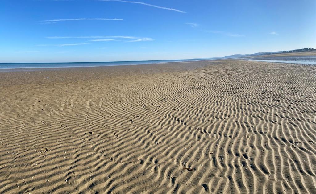 une plage avec des ondulations dans le sable près de l'eau dans l'établissement Logement avec balcon, à Ouistreham
