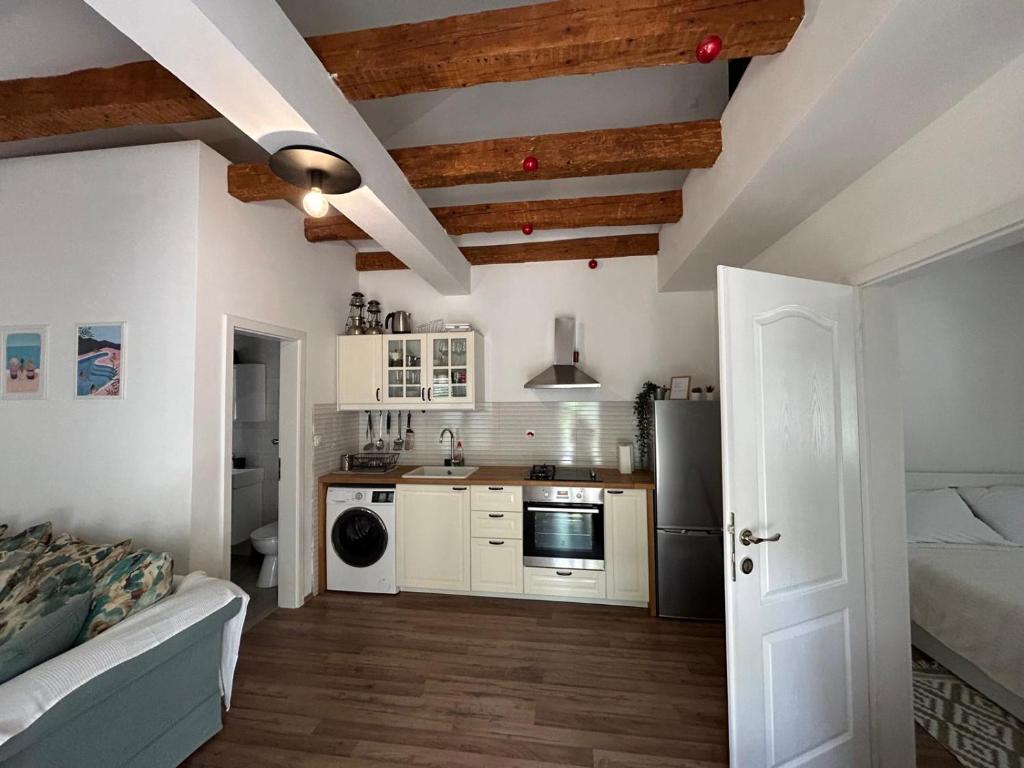 a kitchen with white walls and wooden ceilings at Sweet holiday house in Veli Iž