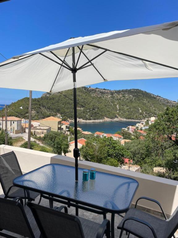 a table and chairs with an umbrella on a balcony at Asos Terrace House in Asos