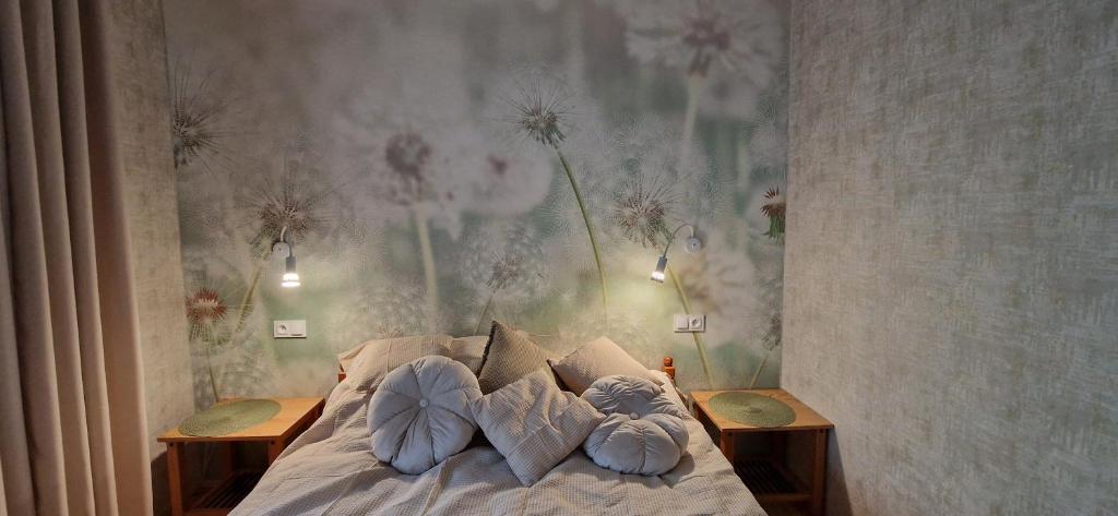 a bedroom with a bed with pillows and a painting on the wall at Apartament nad Jeziorem Necko in Augustów