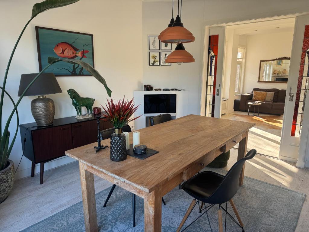 a living room with a wooden table and chairs at Tastefull double story 2 bedroom appartment/house in Haarlem