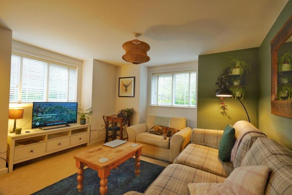 a living room with a couch and a tv at Broomfield Nook - 2 Bed Ground floor Maisonette close to Harry Potter studio tour in Abbots Langley