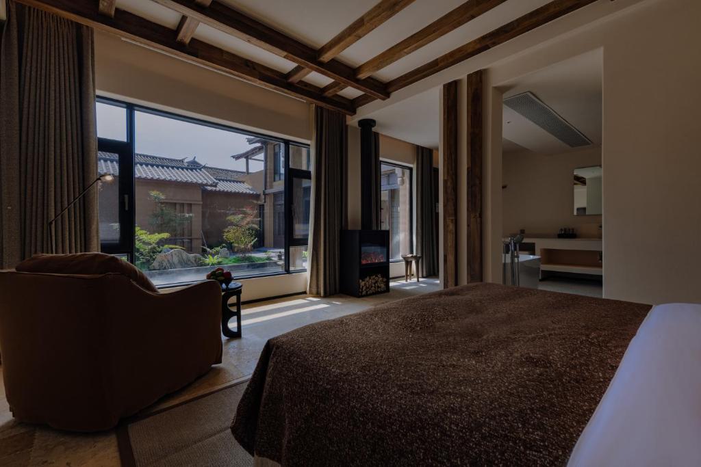DiannanShaxi Fengyasong Village Hotel的一间带床和大窗户的卧室