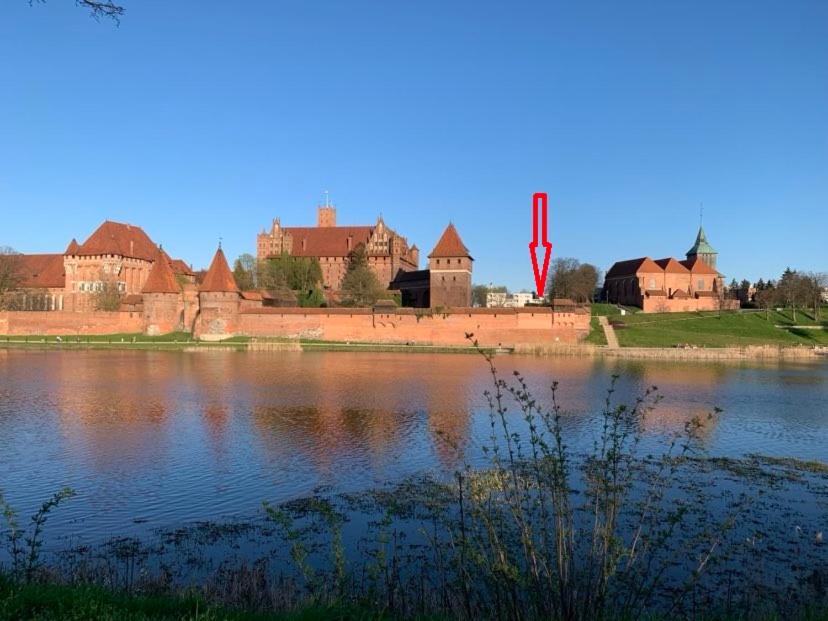 a castle sitting next to a large body of water at Przy ZAMKU in Malbork
