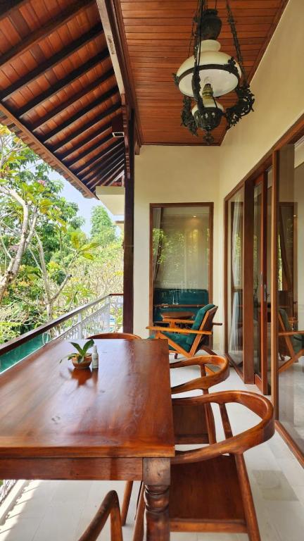 a dining room with a wooden table and chairs at Sapodilla Ubud in Ubud
