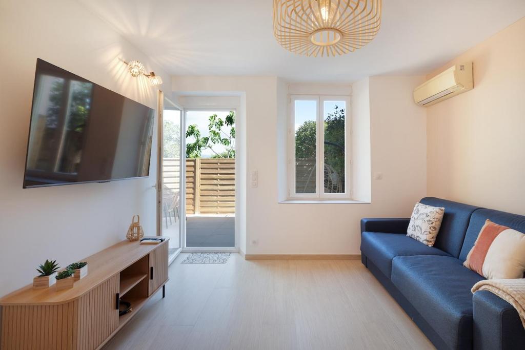 un salon avec un canapé bleu et une télévision dans l'établissement Studio avec Terrasse et piscine, à Antibes
