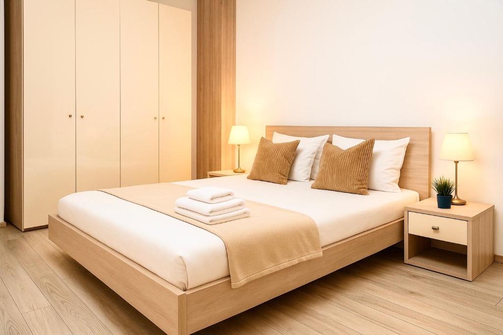 Un dormitorio con una gran cama blanca con dos lámparas. en Central Adress AD8, en Bucarest