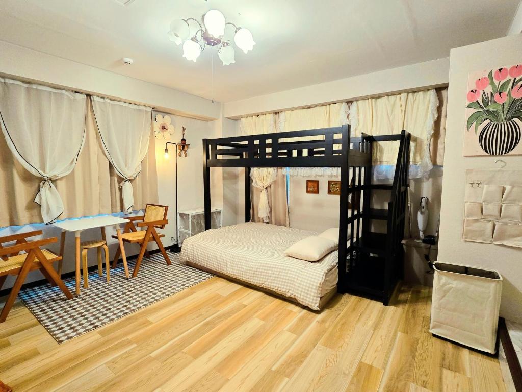 ein Schlafzimmer mit einem Etagenbett, einem Tisch und einem Schreibtisch in der Unterkunft UENO 704 jellynehouse in Tokio