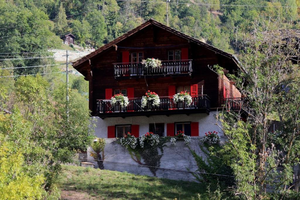 a house with flowers on the balconies of it at Chalet Chinegga in Stalden