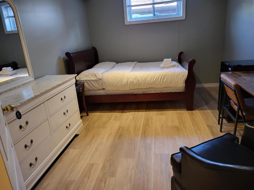 a bedroom with a bed and a dresser and a mirror at May Flowers in Kingston