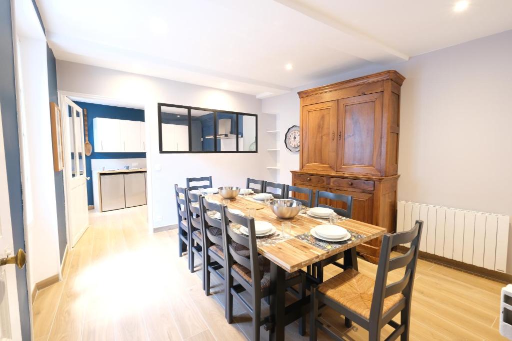 une cuisine et une salle à manger avec une table et des chaises en bois dans l'établissement La maison de Lili, à Sisteron