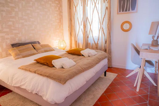 a bed with two pillows and a desk in a bedroom at Deux chambres avec terrasse dans le centre ville d'Aix en Provence in Aix-en-Provence