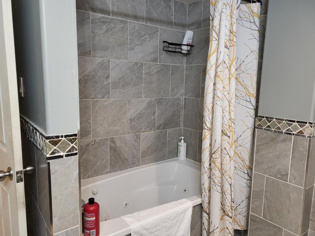 a bathroom with a bath tub with a shower curtain at May Flowers in Kingston