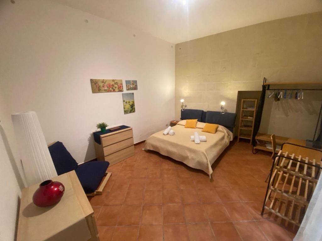 una camera da letto con un letto, un tavolo e delle sedie di Casa Angelica a Siracusa
