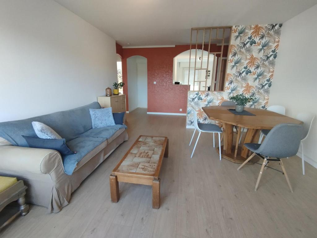 un salon avec un canapé et une table dans l'établissement F3 rénové, à Arbent